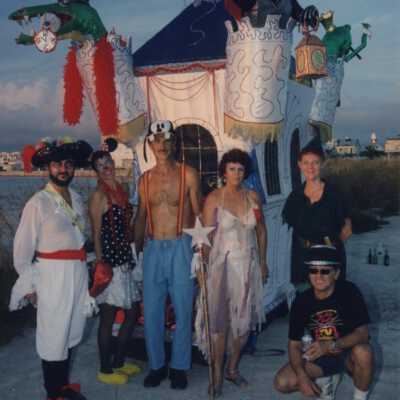 Unknown people dressed up standing in front of a float.