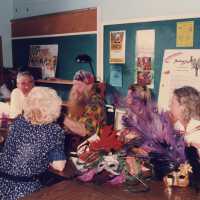 A group of unknown people sitting at a table talking.