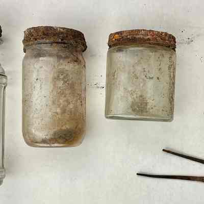 The jar without a lid contained three nails.