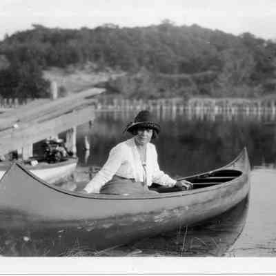 ppl204.jpeg 828KB: Woma in canoe at lighthouse dock with harbor pilings in the background