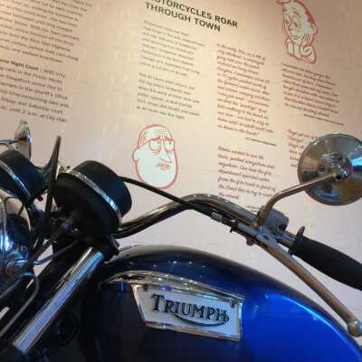 Triumph motorcycle loaned by Paul Quinn: Text 1: 1972 Triumph TR6R Motorcycle
Monday was…like a grand prix motorcycle race in Saugatuck. Rain came but only made them go a little faster. I blame the whole thing on a guy named Brando and a movie called “The Wild One.”
 — Commercial Record, July 8, 1965
After the World War II, motorcycle riders, many of them veterans, formed loosely-organized groups and a new social institution—the motorcycle club — was born. The 1953 film “The Wild One” popularized the outlaw biker persona. 

Text 2: Throughout the 1950s and 1960s, the British Triumph motorcycle, with its powerful parallel twin platform engine, set multiple speed records and race victories. 
The Triumph’s popularity with celebrities like Steve McQueen, Bob Dylan, Elvis Presley and stunt performer Evel Knievel gave motorcycling a sheen of glamour and cool. 
Multitudes of visitors rode to Saugatuck on a Triumph motorcycle.

| Loan from the Quinn family