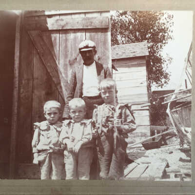 Two generations of fishermen at Fishtown shanty: Father Reuben Sewers (Sr.) with sons George and twins Rube and Frank