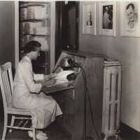          LoisCorkhillDouglas_Hosp; Same photo of Dr. Corkhill on the wall. The seated woman is Lois Corkill, Dr. Corkill's spouse. She continued to serve the Douglas Community hospital.
   