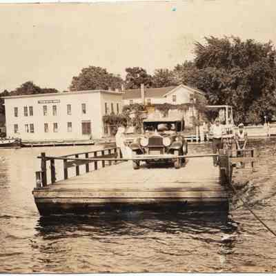 JimorGeorgeCrankingFerry.jpg: Original photo. Jim or George Sheridan cranking ferry. Note about Heath Boats down river. ca 1929 to 1935
