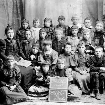 0022 May the Teacher.jpg 1.1MB: MAY AND HER SCHOLARS, c1893-5

May Francis Heath was a school teacher in her youth, first teaching in rural schools, and then the Saugatuck Union School. From the Lakeshore Commercial (Commercial Record) of the times we see that May was hired to teach the primary department of the Ganges School in March 1892, before she had herself received a High School Diploma. In later years she spoke of the poverty of her family as a child and perhaps that is why she went to work so early.

She did get her degree as a member of the Saugatuck High School Class of 1893, giving the Valedictory address, an essay entitled "Drifting", at the June 2, 1893 Commencement Ceremony. Other members of her class were: Archie Pierce, Mae Naughtin, Gilbert Pride, Emma Randall, Ray Nies, and Gertie Shriver (the Salutatorian). May promptly was hired to teach the intermediate grades at the Saugatuck Union School, under Principal James Warnock (1851-1899).

The next year, as a staff member, she was on the commencement program again and presented the "Class History", perhaps a foreshadowing of her future role as Saugatuck village historian.     submitted by Chris Yoder