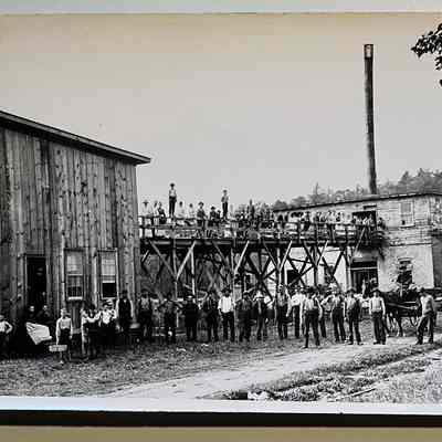5x7 print: 1889 photo of the C. Whitney Basket Factory which was located along the Kalamazoo River in Saugatuck at the corner of Lucy and Butler Streets. The company was in operation from ca 1889 to 1902. The roof and walls were partially covered with sheet-iron for fire protection, thus named the Iron Clad Basket Factory.
