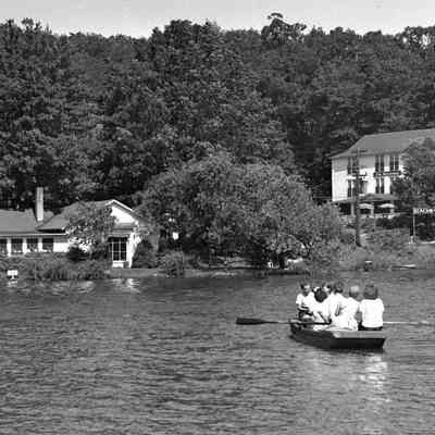 Deam32.jpg 341KB: Passengers being rowed across Kalamazoo River with Ferry Store and Beachway in distance.