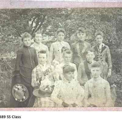 BB-1889SSClass.jpg 2.2MB: 1889 Congregational Sunday School Class- May at Center Rear
(Can you name any of the other girls?)

May writes in her book that Saugatuck's "first real church organization was the Congregational which first met in the school house in Pine Grove in January, 1860. A church building was started in 1861 and completed in 1862. Before the building was completed, Saugatuck citizens met there at the outbreak of the Civil War. The church grew and expanded in its present location, on land given by Henry Breuckman. In the Heath-Morrison photo collection, SDHS has a picture of the structure as it appeared in the early years. This year the Congregational Church has been celebrating its 150th anniversary, with SDHS member Peggy Boyce serving as church historian.

May was an active member throughout her life. She and Doc were married in the church on November 1, 1895, and faithfully supported it financially until their deaths. The Commercial Record includes many articles that speak of her involvement, a few of these include: In January, 1909, she helped the Sunday School class with its Christmas program; she entertained the choir in 1912; in 1915 she hosted a reception for the new minister and his wife; in 1922 she hosted a Missionary Society meeting on China; she directed the Sunday School teachers in 1923; in 1928, she was on the Committee on Resolutions; she presented the History of the Church at its annual meeting of 1929; in 1936, she served as a Trustee and on the Pulpit Supply Committee; and was reported to be a Trustee again in 1937 and 1940.

She was a leader in the Ladies Aid, the church's charitable arm, and served in a variety of roles to include: Vice President in 1916; Secretary in 1919; toastmaster for the annual meeting in 1928; and she became President of the group in 1931, serving in that role for 14 years.

On the occasion of the 90th anniversary of the church in 1950, May wrote and presented the history of the congregation. Her works were much appreciated by the congregation. On Oct. 24, 1947, May ordered a stained glass window for the church of "Jesus at the Door". It was installed the next spring and can be found in the north east corner of the sanctuary.