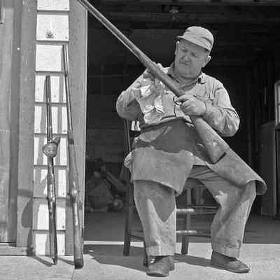 2022.21.840 Fred Davis.jpg: Fred Davis cleaning his guns from the Simmons collection