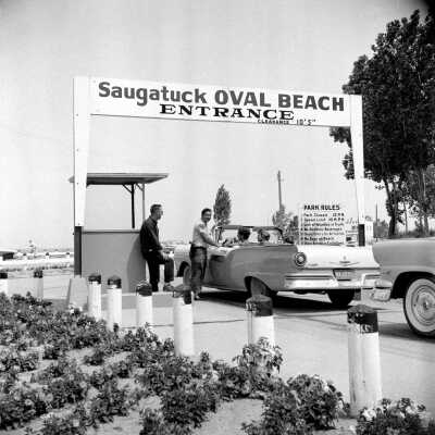 638 0/4 bw	Saugatuck - Beach	1957	Oval entrance, parking 25 cents a638.jpg 2.1MB: At the Oval Gate
[The picture on exhibit poster and the cover of the book] 
"The girls are identified as Susan (Floto) Sisson driving the car she received as a graduation present with Bonnie (Sewers) Kozanecki beside her. In the back seat is Diana (Meyer) Kausen [Sister of Pat (Meyer) Diepenhorst."  - Bonnie Kozanecki
A Blue Ford
"The car in #638 is my "robin egg blue" Ford. Since I was a small child, 1949, my folks brought my brother and I up here. They went into the Ole Crow. We kids played the archery, miniature golf, plus bike for two." - Jeanne (Corliss) Roche.