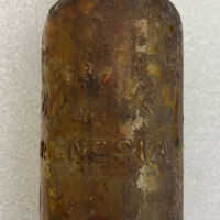          12. Brown glass bottle marked 