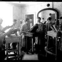          sim art students .jpg 632KB; Art students working on clay relief sculptures in a domestic indoor space. The adult students are wearing smocks and working on raised wooden platforms
   