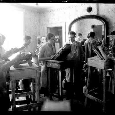 sim art students .jpg 632KB: Art students working on clay relief sculptures in a domestic indoor space. The adult students are wearing smocks and working on raised wooden platforms