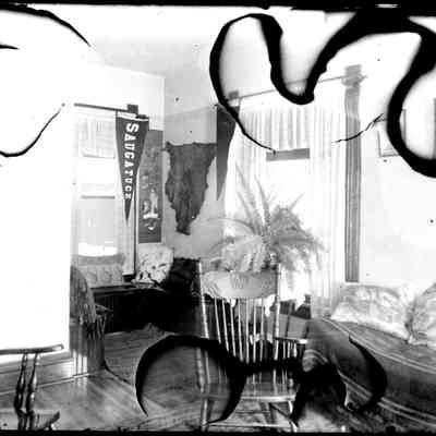sim Bedroom scene w pennant.jpg 438KB: Interior domestic room with two chairs, a fern, a Saugatuck pennant, an Asian scroll, pillows, windows with lacy drapery, a hide, wooden floors, a bed or lounge.