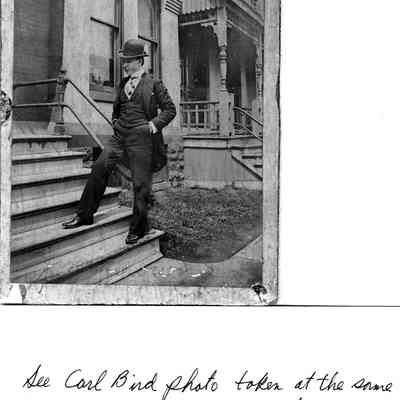 89-1-35 Jim Brown.jpg 434KB: See Carl Bird photo taken at the same time (89-1-25) in front of the same house. [Photo at 2023.10.127] A young man wearing a bower hat striking a jaunty pose on the front steps of a rowhouse.