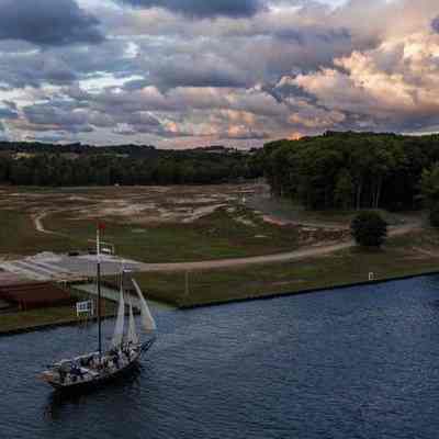 A sailboat passes by a new development on the site of Singapore, a former town at Lake Michigan on the Kalamazoo River near Saugatuck, Michigan, on Sept. 29, 2020. (Zbigniew Bzdak / Chicago Tribune)