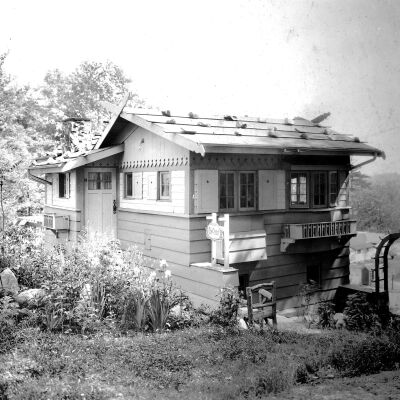 The Challet Studio with a similiar-shaped sign hung on chains.