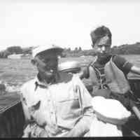          D0012.jpg 3.3MB; Boy with striped shirt, under life vest, motor boating with older man
   