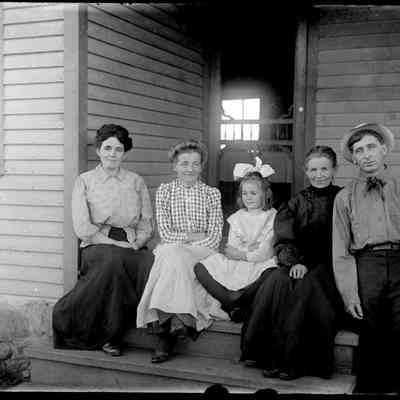 Sim Family Picture.jpg 505MB: Simonson family members sitting on the front steps of a farmhouse. Erma (Crow) Simonson, Sophia (Simonson) Roblyer, unknown girl, Marie Helen Simonson and Herman Simonson.
