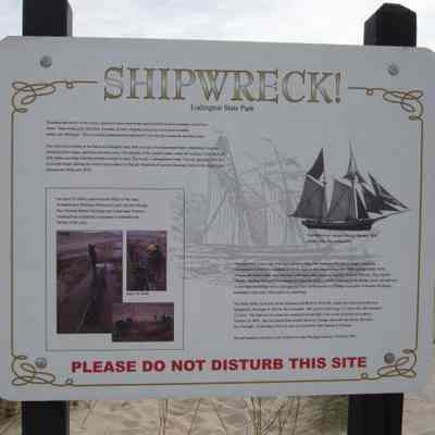 https://www.waymarking.com/waymarks/wm1YQ1_George_F_Foster_Point_Sable_MI: The DNR has outlined the wreck with posts (bow, stern, port and starboard sides) and placed an informational sign at the location.

From the historical information sign on-site:

Receding lake levels of the Great Lakes have uncovered many natural and historical remnants of previous times. Shipwrecks, piers and other remnants of early shipping commerce have been revealed along Lake Michigan. This previous undocumented shipwreck site was discovered [in] the last few years.

On April 19, 2004 a team from the Office of the State Archaeologist, Michigan Historical Center and the Thunder Bay National Marine Sanctuary and Underwater Preserve conducted an exploratory excavation to determine the identity of this ship.

The shipwreck located on the beach a Ludington State Park consists of a centerboard trunk, centerboard, exposed starboard frame heads, and stern and stem posts. The majority of the vessel’s upper works are missing, while the keel hull strakes and bilge elements remain covered in sand. The wreck is oriented bow north. The site measures 94.5 feet in overall length, making the vessel representative of literally hundreds of smaller schooners built on the Great Lakes between the 1840s and 1870s. Almost all of these ships were two-mast schooners what a carrying capacity of about 150 tons. They carried virtually anything that had to be transported from one point to another, but principally lumber, grain, salt and coal. A very large percentage of the contemporary fleet carried lumber to Chicago from ports in Western Michigan. Passengers were more often carried in steamships.

The Point Sable wreck may be the schooner GEORGE F. FOSTER, which was built in Newark (now Saugatuck), Michigan in 1852 by Jacob Randall. She was 93.6 feet long, 21.5 feet wide, and measured 123 tons. The ship was lost when she wrecked a Point Sable with a load of lumber on or about October 19, 1872. She was bound from Grand Haven to Chicago when she was blown off course by a Fall gale. At the time of her loss she was owned by John Hanson of Chicago.

Several hundred schooners were shipwrecked on Lake Michigan between 1830 and 1920.