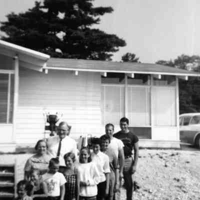 Beaver-family_group.jpg 241KB: Erik Peterson donation/Digital file on Jack Sheridan Drive 2021.72.02
Family posing in the front yard of a residence, possibly on Beaver Island