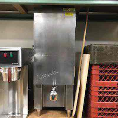 Norris institutional milk dispenser with weighted valve visible at bottom.