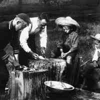          file800.jpg 2.5MB; A man and three boys cleaning fish on a stump
   