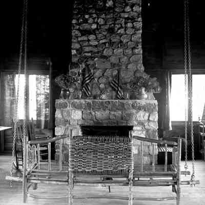 Avalon Interior.jpg 1.1MB: Fireplace in rustic dining-great room. The cottage interior was done in the Arts & Crafts manner—stick furniture, wood plank walls, stone fireplace—and plenty of windows.