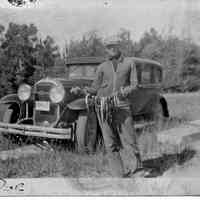          89-1-105B Doc Heath.jpg; A successful day fishing, posted in front of a car with a string of fish. 
