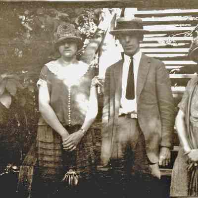 95-52-1bpeople_by_mt_baldhead.jpg 372KB: A man and two women in 1920s-style clothing at the base of a staircase.