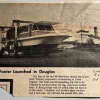          60-Footer Launched in Douglas; The first of the new 60-foot River Queens sits in her
hoist Tuesday preparatory to launching at Tower Marina. The hoist and the launching slip had to be widened to accommodate the big, aluminum-hulled boat. A flying bridge will be added after the boat is in the water. Complete with smoked glass windows and a teak rail, she will sell for around $100, 000.
   