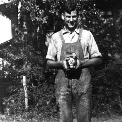 Book 2003 PC.14 - farmer or man in overalls holding a camera: 203 KB