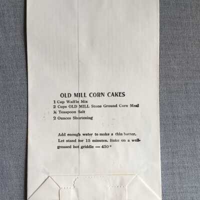 back of bag features recipe for Old Mill Corn Cakes: According to Erik Peterson these cakes were such a popular offering at the nearby Elbow Room restaurant sometimes Erik would get a panicked phone call from the restaurant's cook asking him to grind more corn.