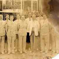          89-1-000namesOnBack.jpg 627KB; Eleven men in light-colored suits standing together for a group portrait. Many of the men have matching suits suggesting they are a  band or a wedding party. The location may be outside the Big Pavilion box office.
   