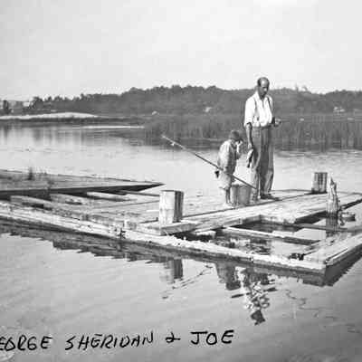 GeorgeHFishing.jpg 878KB: Lighthouse keeper George H. Sheridan with son Joe bass fishing "north end of old..." circa 1910