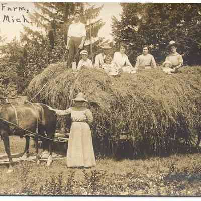 014.Hayride.FairviewFarmDouglas.jpg 256KN: Fairview Farm, Douglas. Two horses are harnessed to a wagon loaded with hay. Four adults, three children and a driver are ready for a hayride. A woman wearing a hat stands with one hand on a horse's rump.