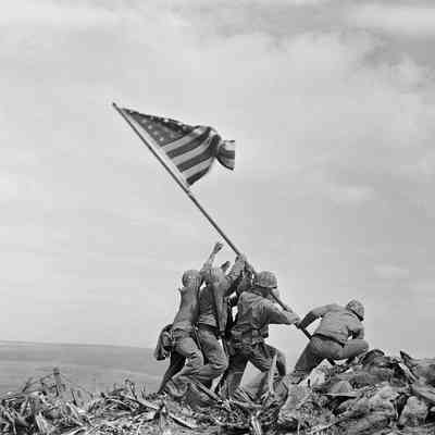 Raising the Flag on Iwo Jima, by Joe Rosenthal: "Raising the Flag on Iwo Jima" is an iconic photograph of six United States Marines raising the U.S. flag atop Mount Suribachi during the Battle of Iwo Jima in the final stages of the Pacific War.  Taken by Joe Rosenthal of the Associated Press on February 23, 1945, the photograph was published in Sunday newspapers two days later and reprinted in thousands of publications. It won the 1945 Pulitzer Prize for Photography and has come to be regarded in the United States as one of the most recognizable images of World War II.  The photograph was the model for the 1954 Marine Corps War Memorial in Arlington, Virginia and has been reproduced on postage stamps, coins and posters.
Source: https://en.wikipedia.org/wiki/Raising_the_Flag_on_Iwo_Jima