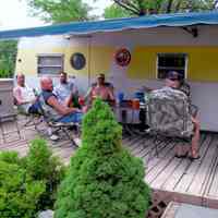          Camp_It2.jpg 718KB; Men enjoying the shade of a trailer's awning with deck furniture.
   