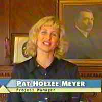          Pat Hoezee Meyer in front of a portrait of Dorr Felt
   