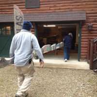          Dec. 8. 2011 totem restoration; Marilyn Starring and unidentified man carry the totem into Arnold Schafer's garage
   