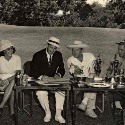 Games.Golf.Heuchan03.jpg 1.3MN: Westshore Golf Course St. Louis at Douglas golf joust. Three man and woman sit at card tables with a selection of trophies and awards. Photo by Don Heuchan of St. Louis, MO. Date stamped Jul 19, 1963.