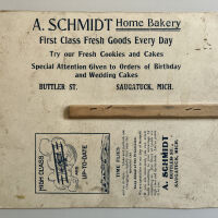          Reverse side of A. Schmidt Home Bakery hand fan.; The handle is broken.
   