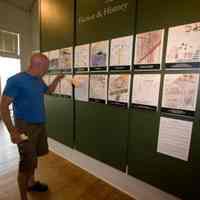          James Schmiechen, museum chair, checks out a student's short story, displayed underneath the drawings.
   