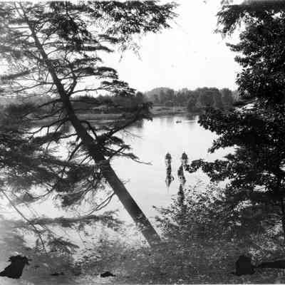 95 84 1 Kalamazoo scene.jpg 1.2MB: Box 31, envelope 95-84-1. For canoes on a smooth water are visible through the hemlock and oak branches on the shore.