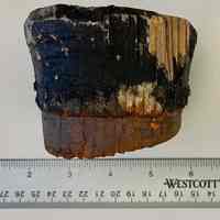          Wooden bung or stopper, partially painted black, side view.
   