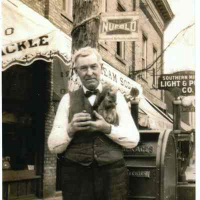 c e bird with squirrel.jpg 1.9MB: Charles E. Bird with a befriended squirrel in front of H.A. Heath building