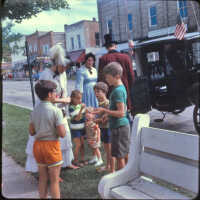          Page E, 6. Kids at parade, same parade as E1; Woman in long blue dress likely Mrs. Henry Brady
   