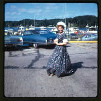          Page D, 19. Woman in historic dress at boardwalk parking lot, 1968. Likely Saugatuck Village Centennial.
   
