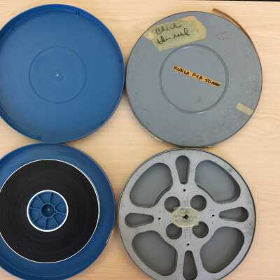 At left, the new, archival, blue plastic canister and film. At right, the original metal can, now empty.
