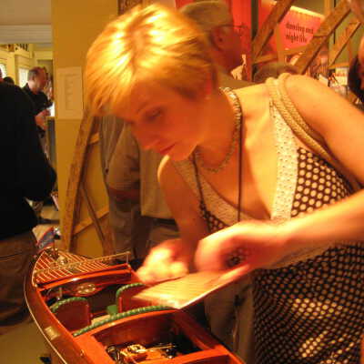 Sally Winthers makes quick repair to Chris-Craft model at opening